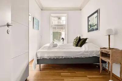 a white bedroom with a bed and a window at Dinbnb Apartments I Characteristic Townhouse with Bathtub in Bergen
