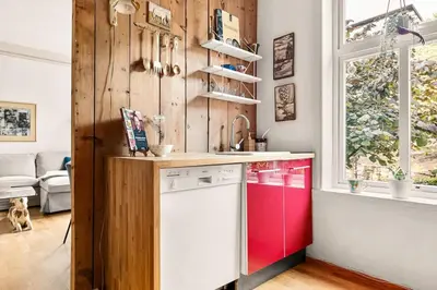 a kitchen with a red and white dishwasher at Dinbnb Apartments I Characteristic Townhouse with Bathtub in Bergen
