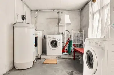 a laundry room with a washing machine and a washer at Dinbnb Apartments I Characteristic Townhouse with Bathtub in Bergen