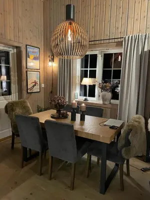 a dining room table with chairs and a chandelier at Leilighet i vakre Rauland in Rauland