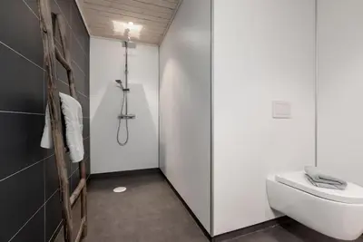 a bathroom with a white toilet and a shower at Hodlekvevegen 308 - Flott hytte midt i skisenteret in Sogndal