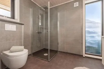 a bathroom with a toilet and a glass shower at Hodlekvevegen 308 - Flott hytte midt i skisenteret in Sogndal