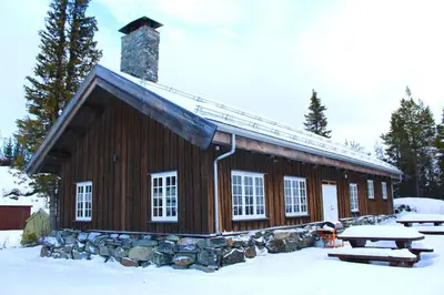 a log cabin in the snow with a picnic table at Grindastugu cabin right by Liatoppen Ski Centre. in Ål