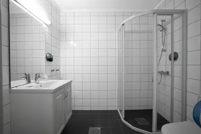 a white bathroom with a sink and a shower at Smuksjøseter Fjellstue in Høvringen