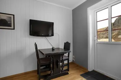 a room with a desk and a tv on a wall at Smuksjøseter Fjellstue in Høvringen