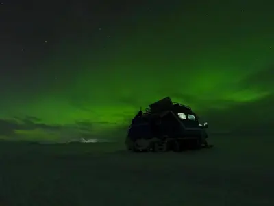 a truck parked in the snow under a green sky at Smuksjøseter Fjellstue in Høvringen