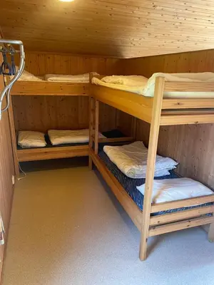 a bunk bed with three bunk beds in a cabin at Midttun Camping og Feriehytter in Vossestrand