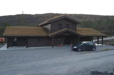 a car parked in front of a log cabin at Stor og koselig hytte i Stryn in Stryn