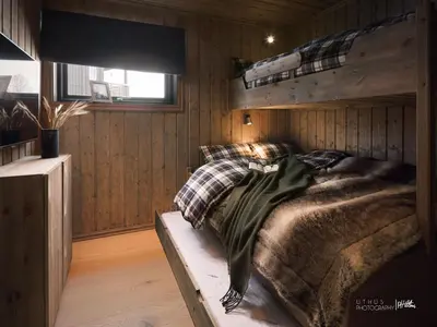 a bedroom with a bed in a wooden wall at Beautiful apartment - high standard - Geilo centre in Geilo