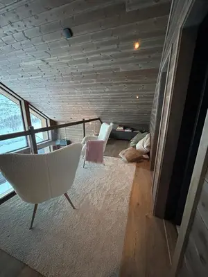 a living room with two chairs and a balcony at Rindabotn Fjelltun ski in-ski out in Sogndal