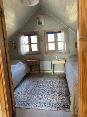a bedroom with two beds and a rug in a attic at Sveggvika Atlantic Home in Averoy