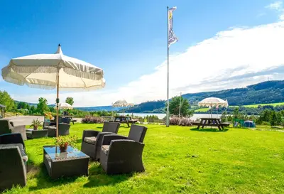 a group of chairs and tables with an umbrella at Lillehammer Turistsenter Camping in Lillehammer