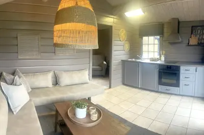 a living room with a couch and a kitchen at Lillehammer Turistsenter Camping in Lillehammer
