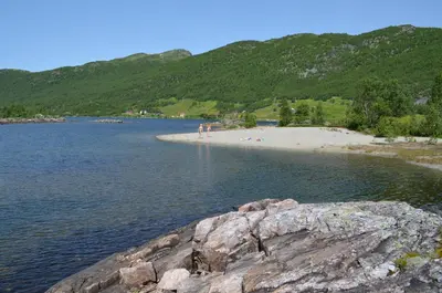 a group of people standing on a beach in the water at Hovden Høyfjellsenter in Hovden