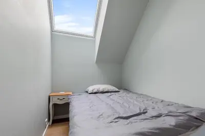 a small bedroom with a bed and a window at Modern house by the Fjord in Sandane, Nordfjord. in Sandane