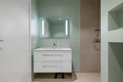 a bathroom with a white sink and a mirror at Modern house by the Fjord in Sandane, Nordfjord. in Sandane