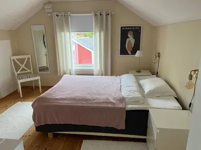 a bedroom with a large bed and a window at Sjarmerende og romslig bolig, omgitt av vakker natur in Molde