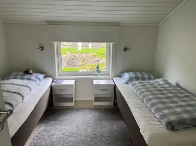 two beds in a room with a window at Sjarmerende og romslig bolig, omgitt av vakker natur in Molde