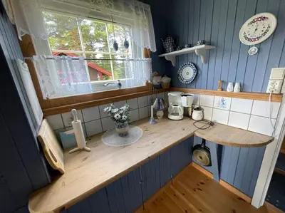 a kitchen with a wooden counter top with a window at Sjarmerende hytte omgitt av vakker natur in Molde