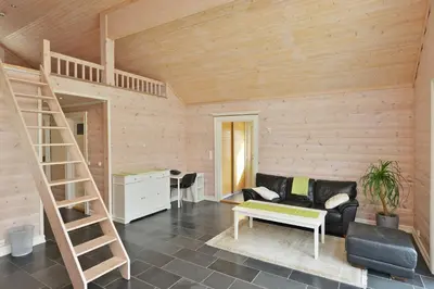 a living room with a black couch and a wooden wall at Elton Hotel in Raufoss