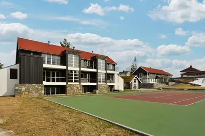a building with a tennis court in front of it at Elton Hotel in Raufoss