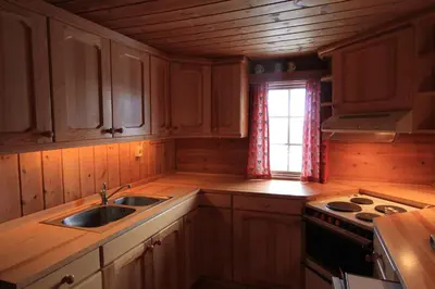 a kitchen with wooden cabinets and a sink and a window at Lusæter Timber Cabins in Heidal