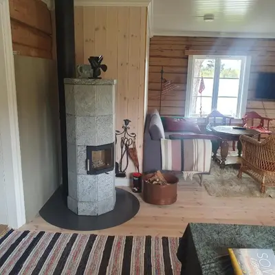 a living room with a stone fireplace in a house at Brekkveien 81-meget sentral hytte,15 min å gå til Røros sentrum in Røros
