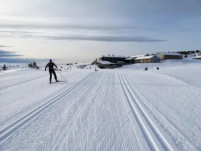 a man is skiing down a snow covered slope at Hafjell Front 220D 8pers, Ski inout , Downhill Bike in Hafjell