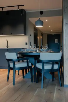 a dining room with a blue table and chairs at Highland Lodge Fjellandsby in Geilo