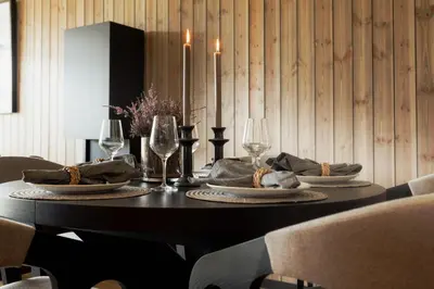 a dining room table with plates and wine glasses at Highland Lodge Fjellandsby in Geilo