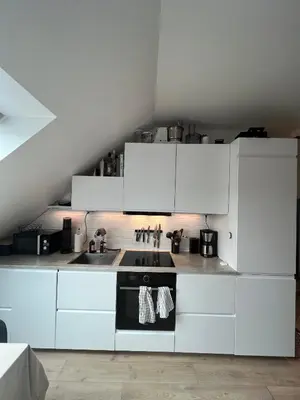 a white kitchen with a stove and a sink at Central Two Room Apartment! in Trondheim