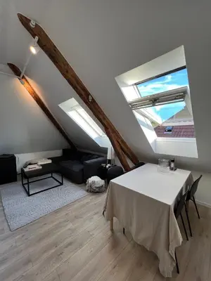 a living room with a table and a ceiling with skylights at Central Two Room Apartment! in Trondheim