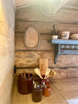 a corner of a wooden cabin with wooden utensils at Kufjøset in Skjåk