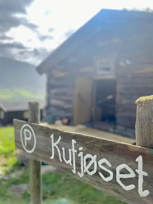 a wooden sign in front of a house at Kufjøset in Skjåk
