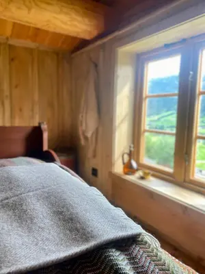 a bedroom with a bed and a window at Kufjøset in Skjåk