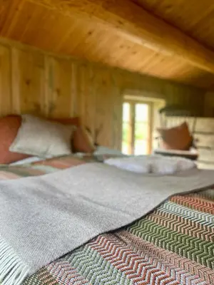 a bedroom with two beds and a wooden ceiling at Kufjøset in Skjåk