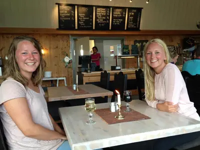 two women sitting at tables in a restaurant at Bessheim Fjellstue og Hytter in Bessheim