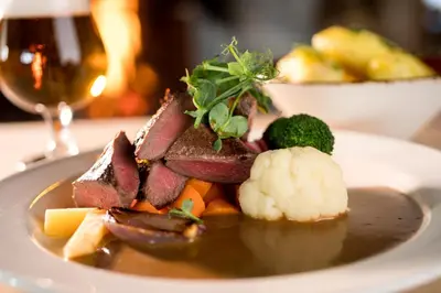 a plate of food with meat and vegetables on a table at Bessheim Fjellstue og Hytter in Bessheim