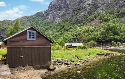 a small building in a field with a mountain at 4 Bedroom Stunning Home In Fjæra in Fjæra