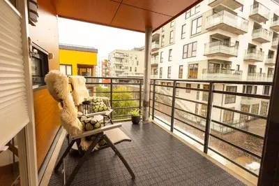 a balcony with a chair and a view of a building at Leilighet Damsgård , nær sentrum in Bergen