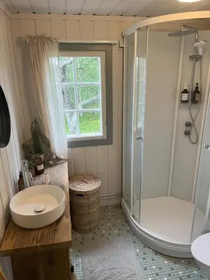 a bathroom with a shower and a toilet and a sink at Cozy family friendly cabin at beautiful location! in Geilo