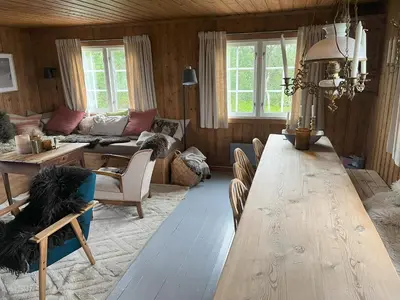 a living room with a large wooden table and a couch at Cozy family friendly cabin at beautiful location! in Geilo