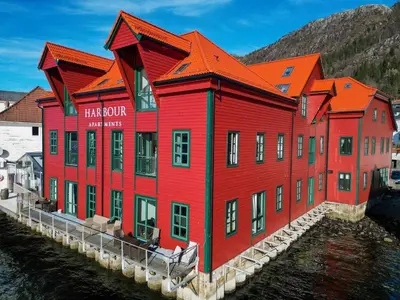 a red building next to a body of water at Central Seafront Apartments with Parking and Self Check-In! in Bergen