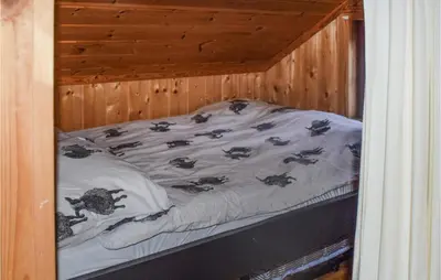a small bed in a wooden room with a bedvisor at 3 Bedroom Stunning Home In Rjukan in Gaustablikk