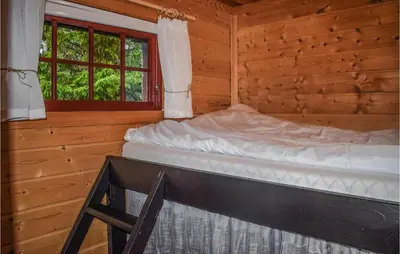 a bed in a log cabin with a window at 3 Bedroom Stunning Home In Rjukan in Gaustablikk