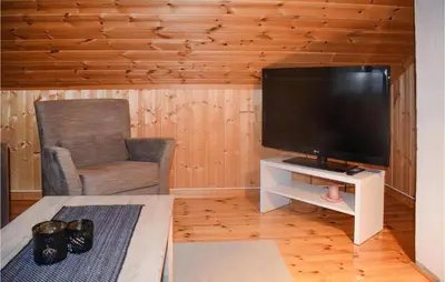 a living room with a flat screen tv and a chair at 3 Bedroom Stunning Home In Rjukan in Gaustablikk