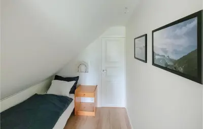 a small bedroom with a bed and a night stand at 3 Bedroom Lovely Home In Stolmen