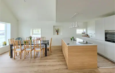 a kitchen and dining room with a table and chairs at 3 Bedroom Lovely Home In Stolmen