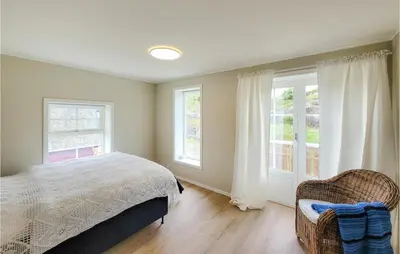 a bedroom with a bed and two windows at 3 Bedroom Lovely Home In Stolmen
