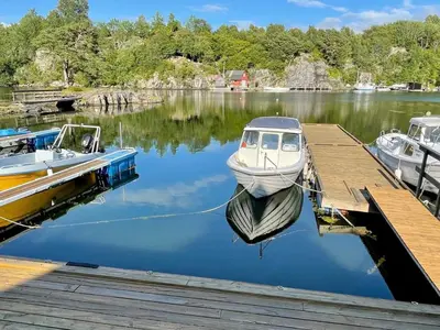 a boat is docked at a dock on a lake at 9 person holiday home in MOSTERHAMN-By Traum in Mosterhamn